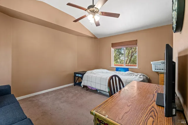 a bedroom with a bed and a flat tv screen on the dresser