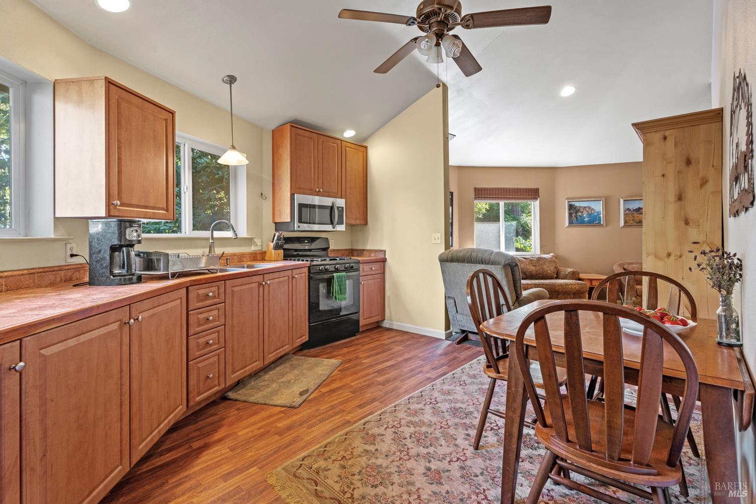 16460 Walker Lake Road Willits, CA 95490 - Photo 9 of 23 a kitchen with stainless steel appliances granite countertop a stove a sink dishwasher a dining table and chairs with wooden floor