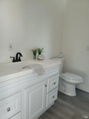 a bathroom with a granite countertop toilet sink and mirror