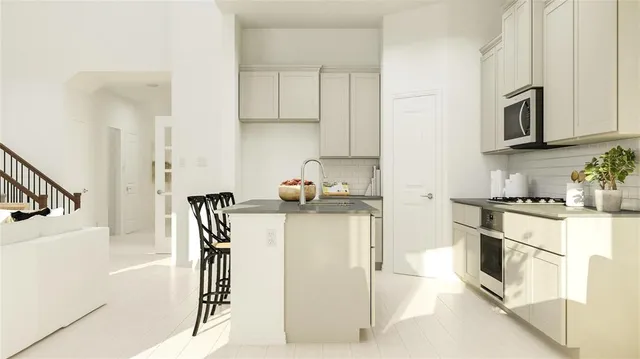 a kitchen with stainless steel appliances granite countertop a refrigerator and white cabinets