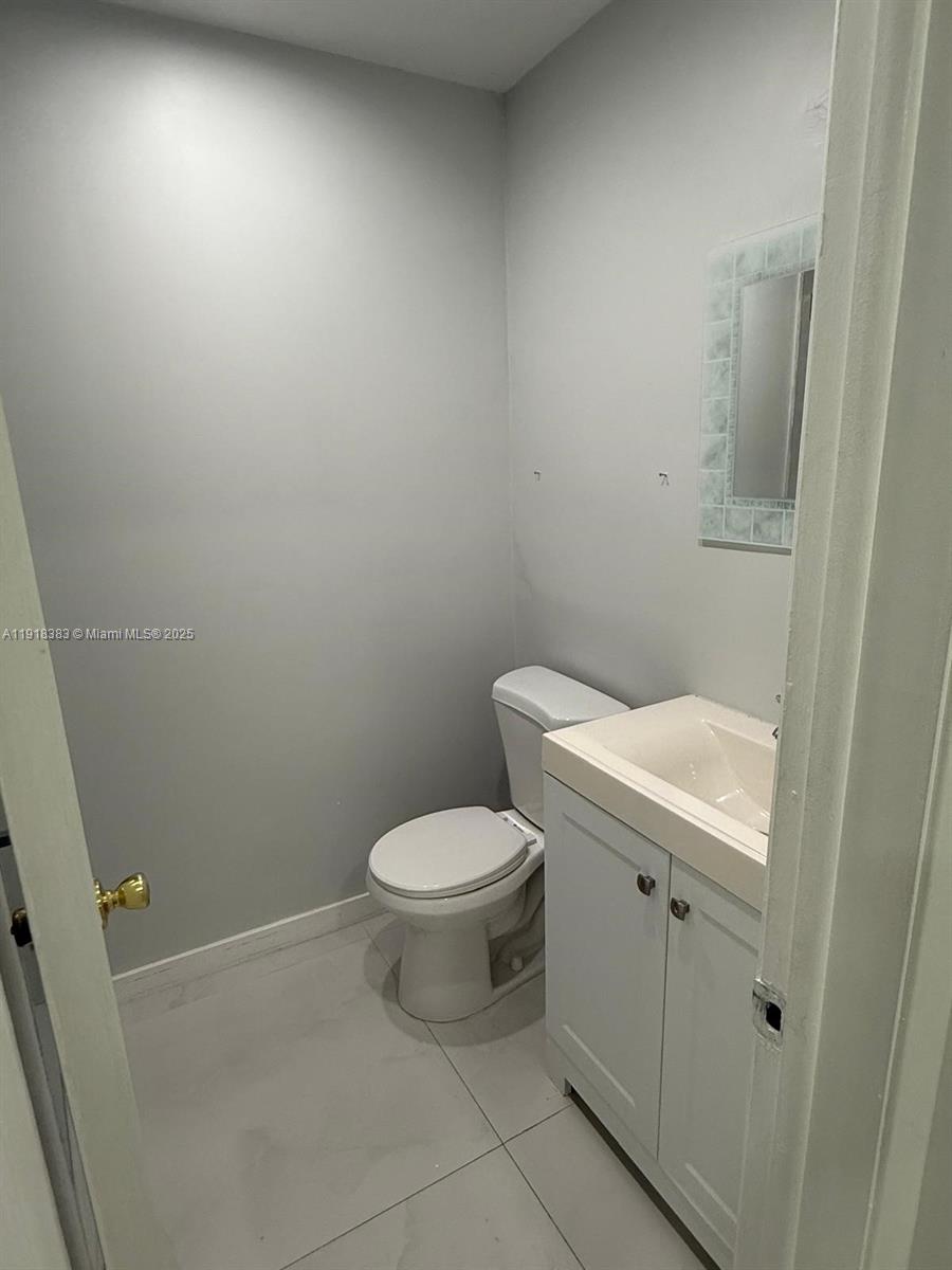 2461 Southwest 82nd Avenue, Unit 105 Davie, FL 33324 - Photo 17 of 17 a white toilet sitting next to a white sink and vanity