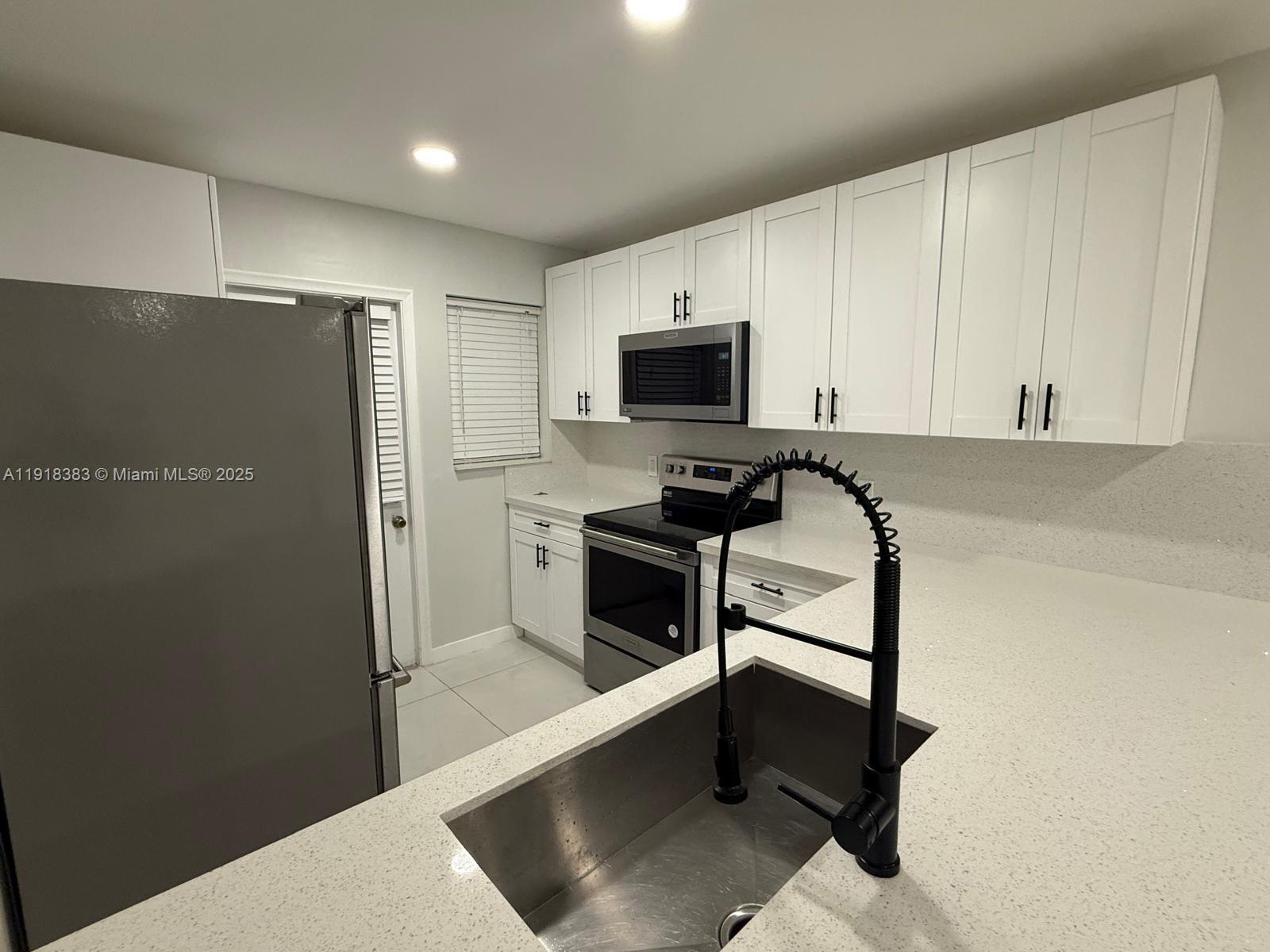 2461 Southwest 82nd Avenue, Unit 105 Davie, FL 33324 - Photo 8 of 17 a kitchen with white cabinets and stainless steel appliances