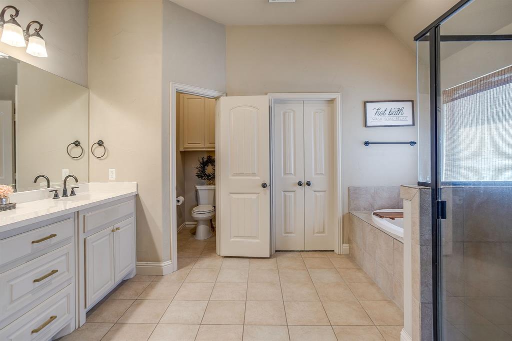 43 Crown Road Willow Park, TX 76087 - Photo 20 of 40 a spacious bathroom with a granite countertop sink a toilet a mirror and shower