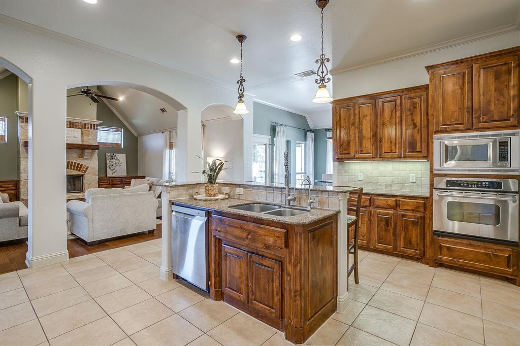 43 Crown Road Willow Park, TX 76087 - Photo 8 of 40 a kitchen with kitchen island granite countertop a stove oven and a sink