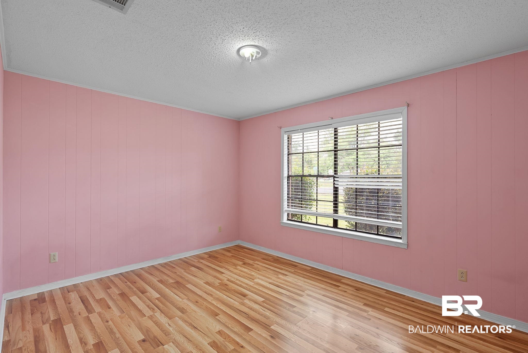 716 North Cedar Street Foley, AL 36535 - Photo 17 of 25 Room with wood-finish flooring, a window with horizontal blinds, and a flush mount ceiling light fixture