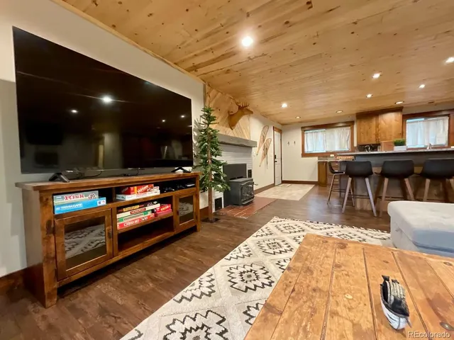 a living room with stainless steel appliances furniture and a flat screen tv