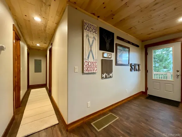 a view of a hallway with wooden floor and entryway