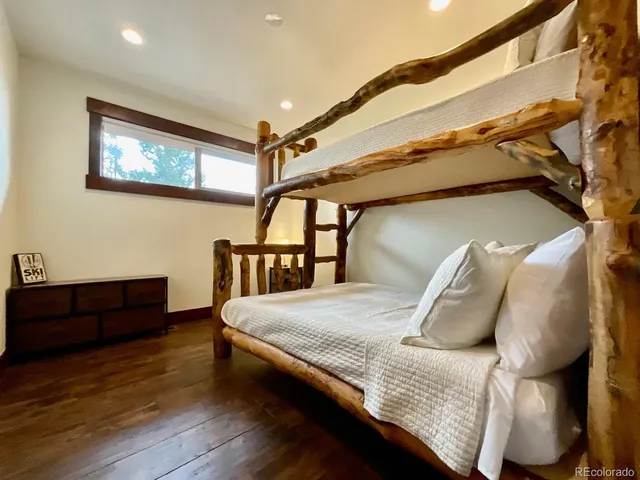 a bedroom with a bed with wooden floor