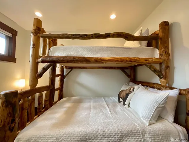 a bed sitting in a bedroom next to a lamp