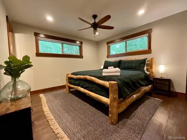 a bedroom with a bed potted plant with the wooden floor