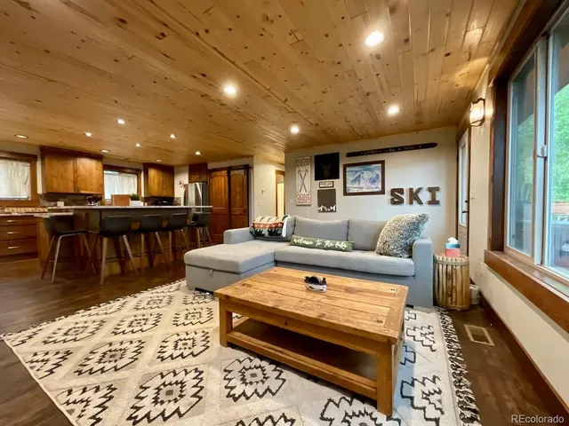 a living room with stainless steel appliances furniture and a table