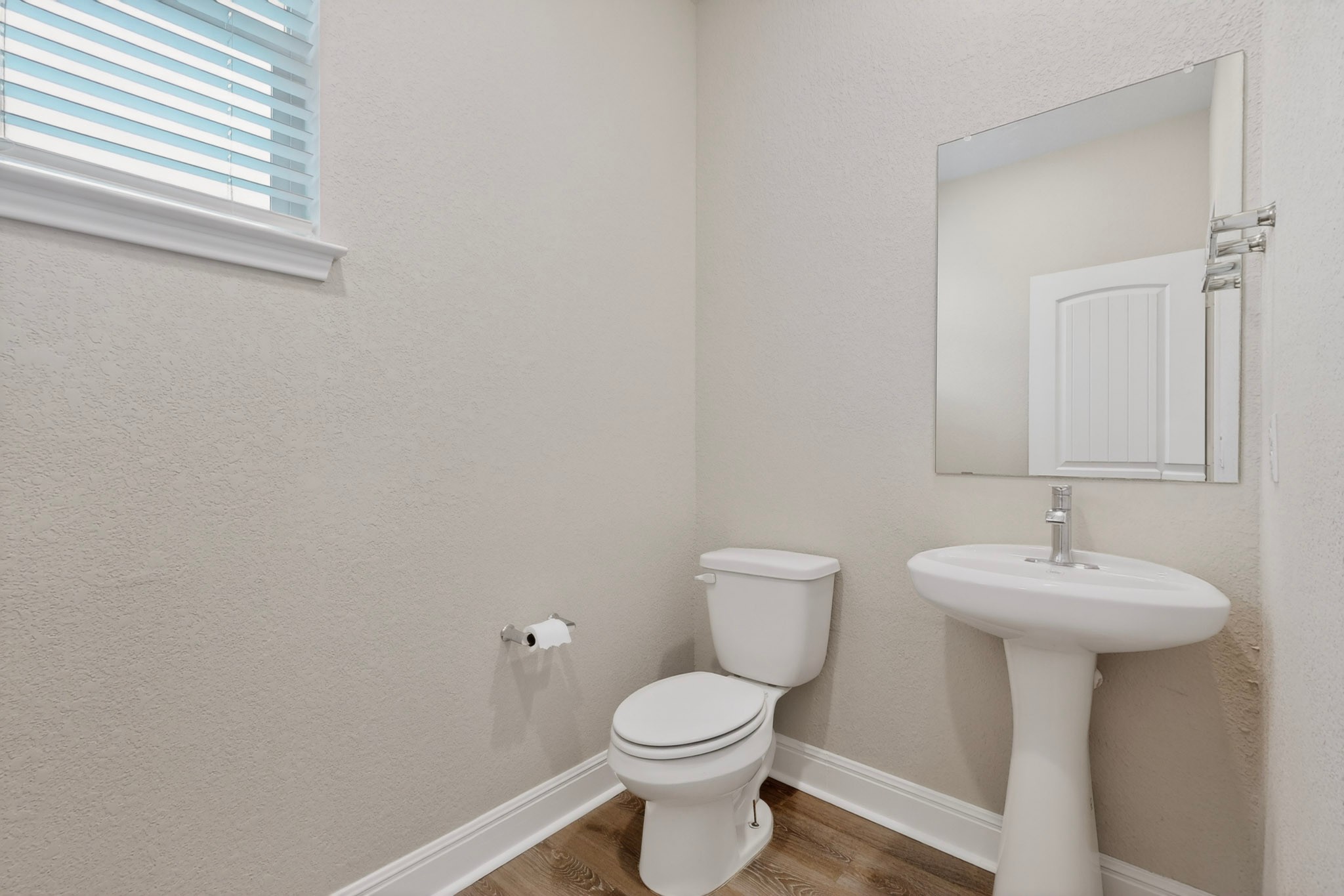 16809 Guido Cove Pflugerville, TX 78660 - Photo 14 of 40 Pedestal sink with chrome faucet, toilet, and a rectangular mirror