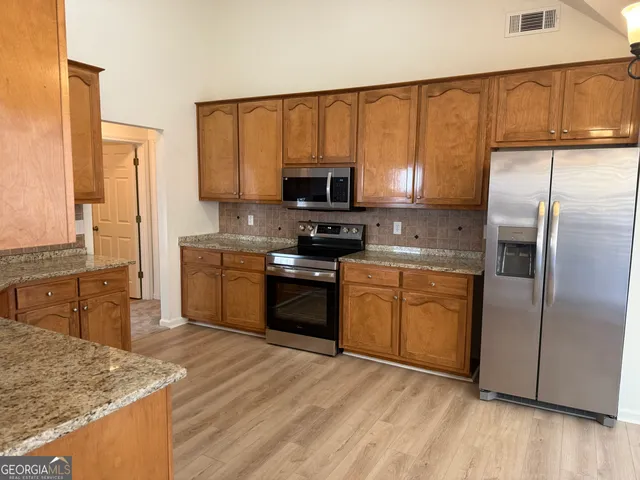a kitchen with a refrigerator sink and cabinets