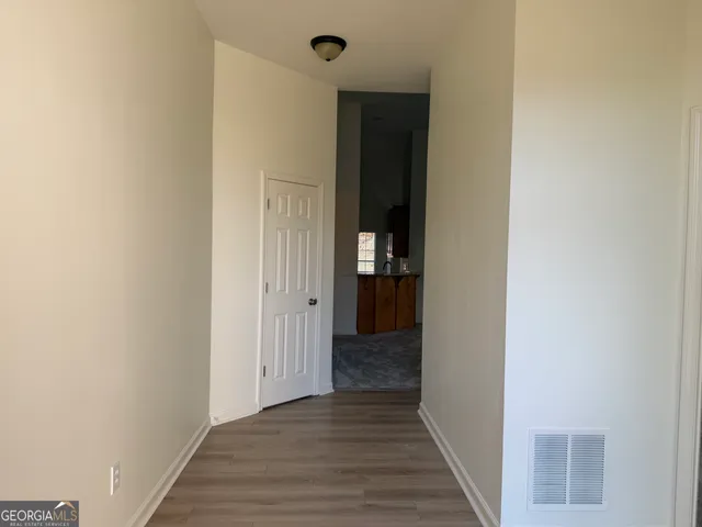 a view of a hallway with wooden floor