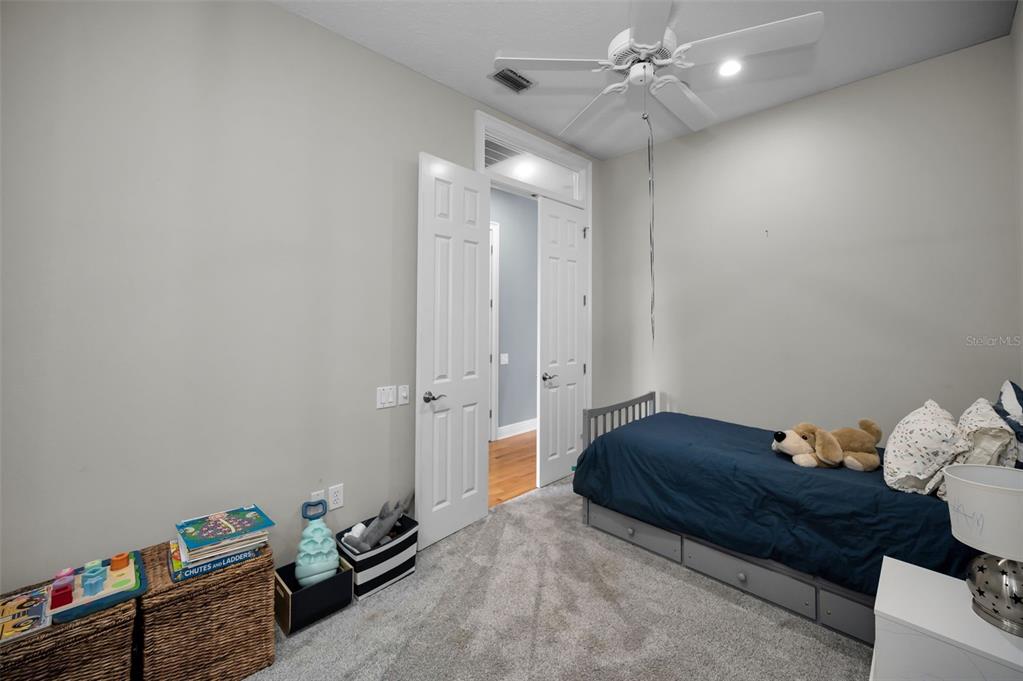 8871 Silverthorn Road Seminole, FL 33777 - Photo 78 of 98 a spacious bedroom with a bed and a ceiling fan