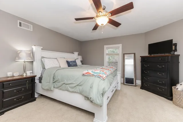 a bedroom with a bed and a ceiling fan