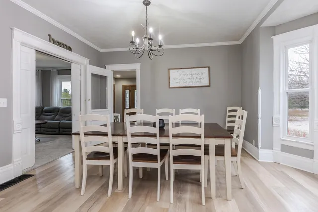 a dining room with furniture a chandelier and wooden floor