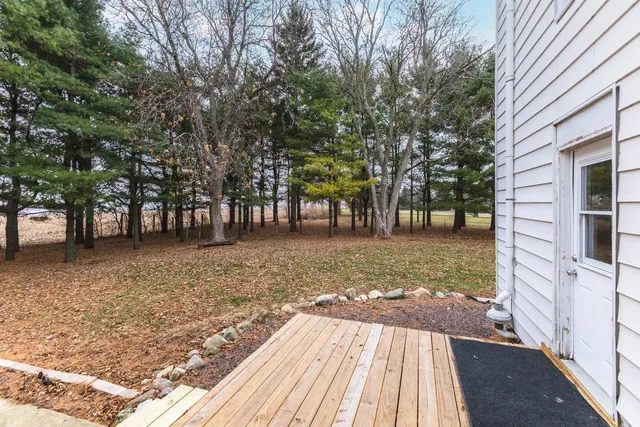 a view of a patio with table and chairs with wooden floor and fence