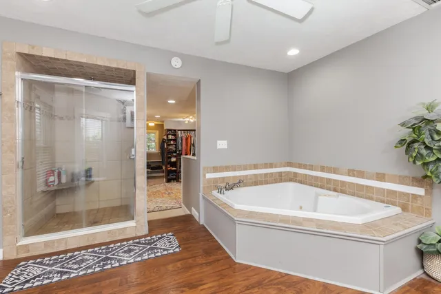 a spacious bathroom with a tub sink and mirror