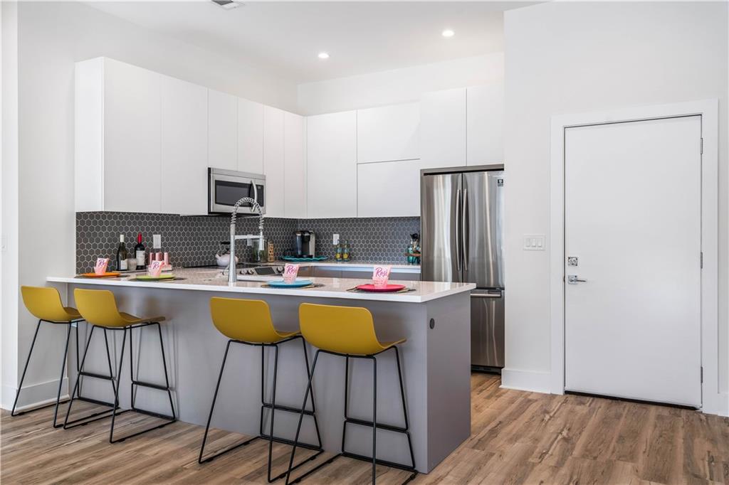 1155 Custer Avenue Southeast, Unit 202 Atlanta, GA 30316 - Photo 6 of 13 a kitchen with a table chairs refrigerator and cabinets