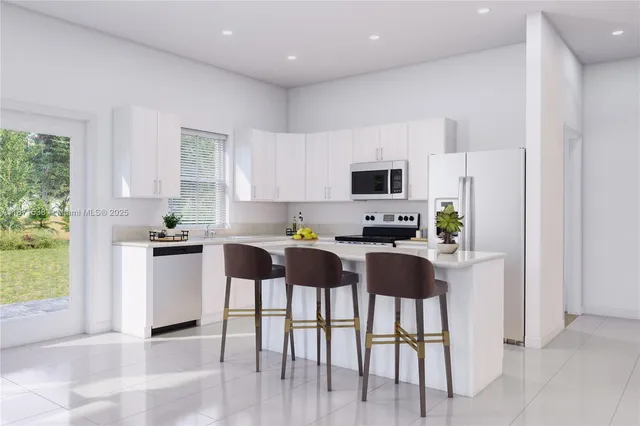 a kitchen with stainless steel appliances a stove top oven a refrigerator a sink and a cabinets