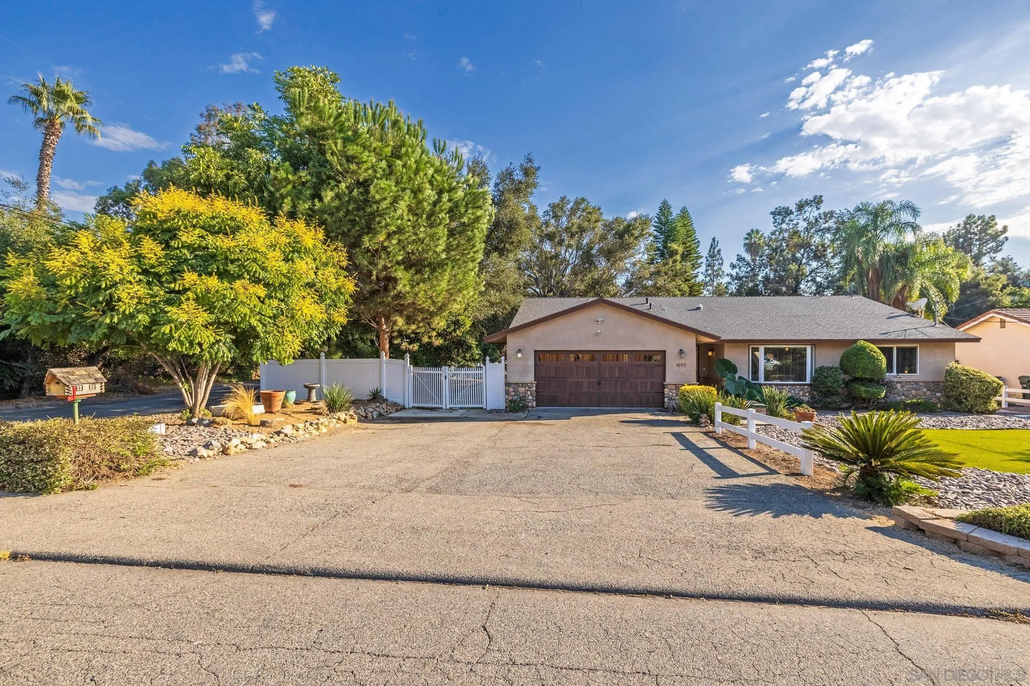 1695 Calmin Way Fallbrook, CA 92028 - Photo 4 of 44 a front view of a house with a yard and garage