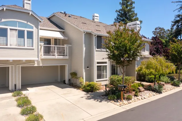 a front view of a house with a yard and potted plants