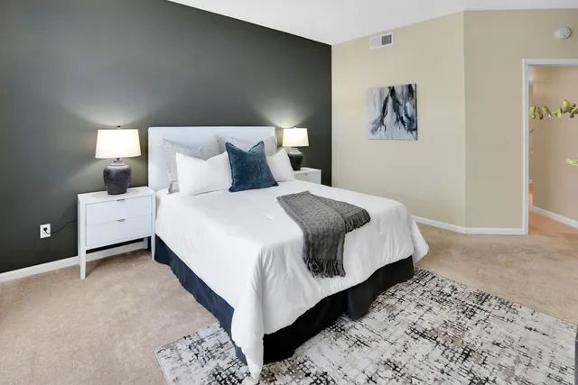 a bed room with a bed and painting on the wall