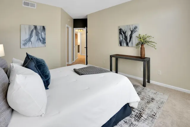 a bedroom with a bed and a painting on the wall