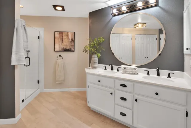 a bathroom with a double vanity sink mirror and bathtub