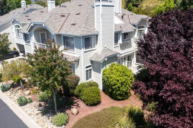 a view of a white house with a flower garden