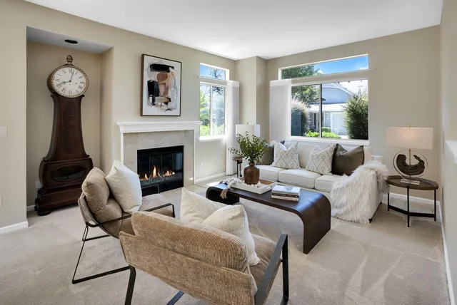 a living room with furniture a clock and a fireplace
