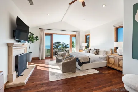 a bedroom with two beds and a large mirror next to a window