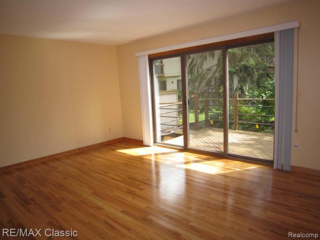 23163 Farmington Road, Unit 49 Farmington, MI 48336 - Photo 7 of 14 Living Room with hardwood floors & doorwall out to 8x23 deck.