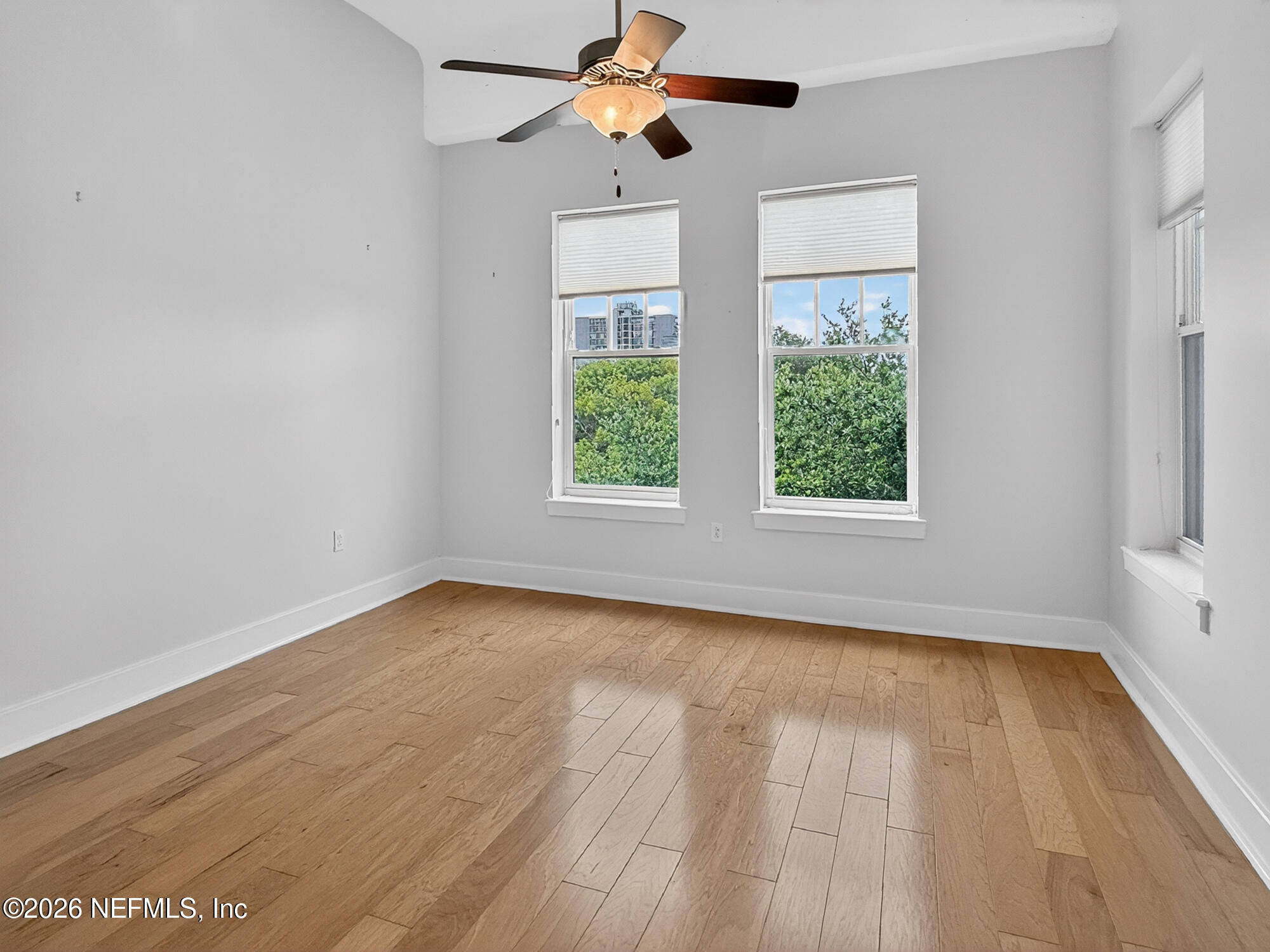 1661 Riverside Avenue, Unit 407 Jacksonville, FL 32204 - Photo 14 of 60 an empty room with wooden floor ceiling fan and windows