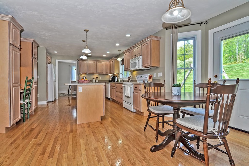 36 Proctor Road Townsend, MA 01469 - Photo 10 of 29 a kitchen with stainless steel appliances a dining table chairs and wooden floor