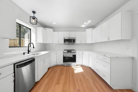 a kitchen with stainless steel appliances a stove sink and cabinets