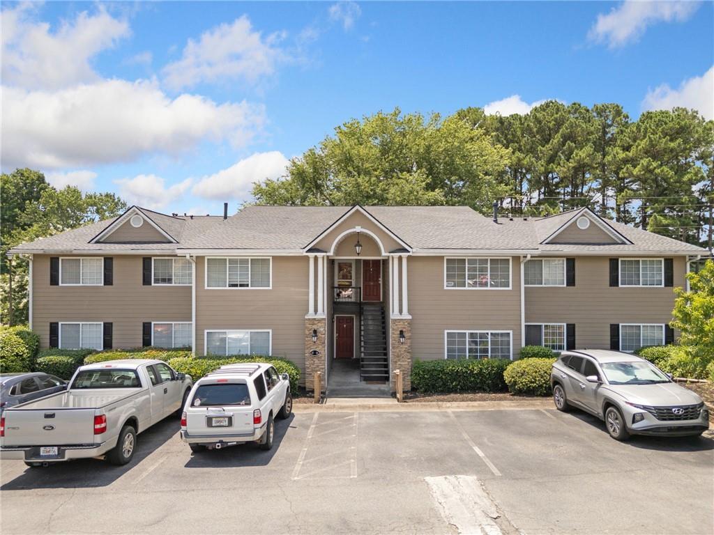 a front view of a house with cars parked