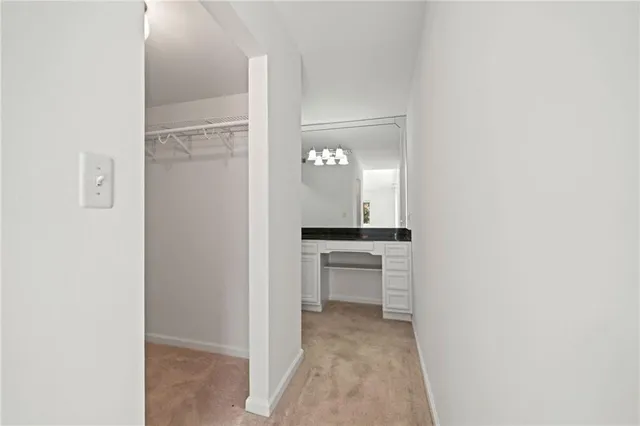 a view of a hallway and a livingroom with a chair