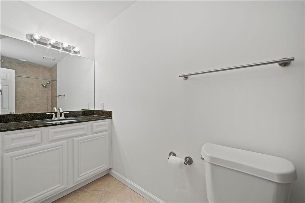 1468 Briarwood Road Northeast, Unit 108 Atlanta, GA 30319 - Photo 22 of 33 a bathroom with a granite countertop sink a toilet and a mirror