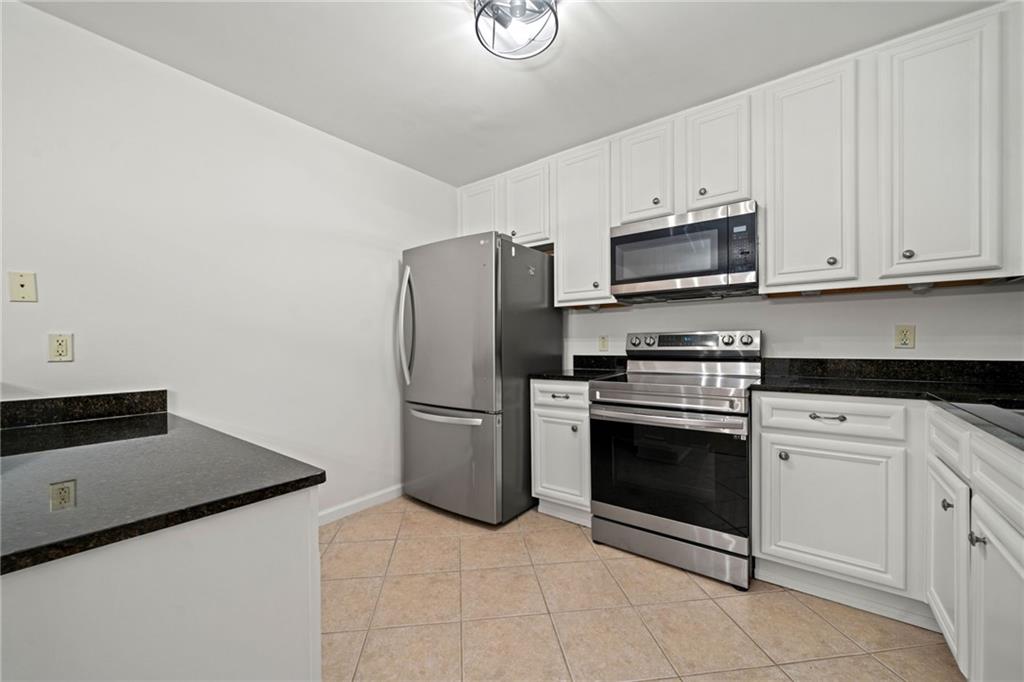 1468 Briarwood Road Northeast, Unit 108 Atlanta, GA 30319 - Photo 6 of 33 a kitchen with cabinets stainless steel appliances and a sink