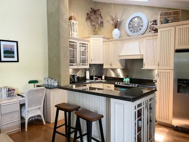 a kitchen with granite countertop a table chairs stove and cabinets