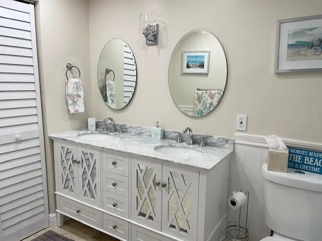 a bathroom with a granite countertop toilet a sink and a mirror