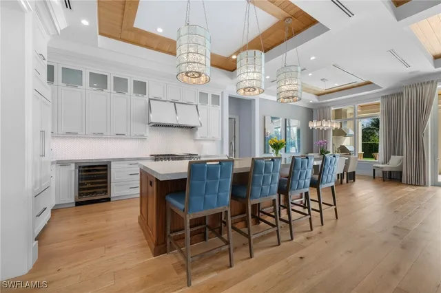 a kitchen with stainless steel appliances kitchen island granite countertop a table and chairs in it