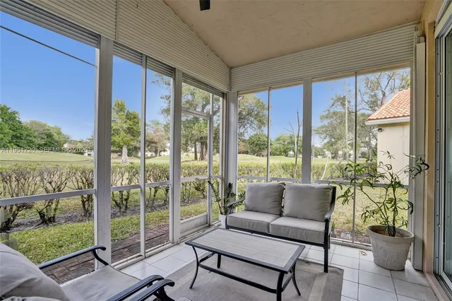 a living room with furniture and a floor to ceiling window
