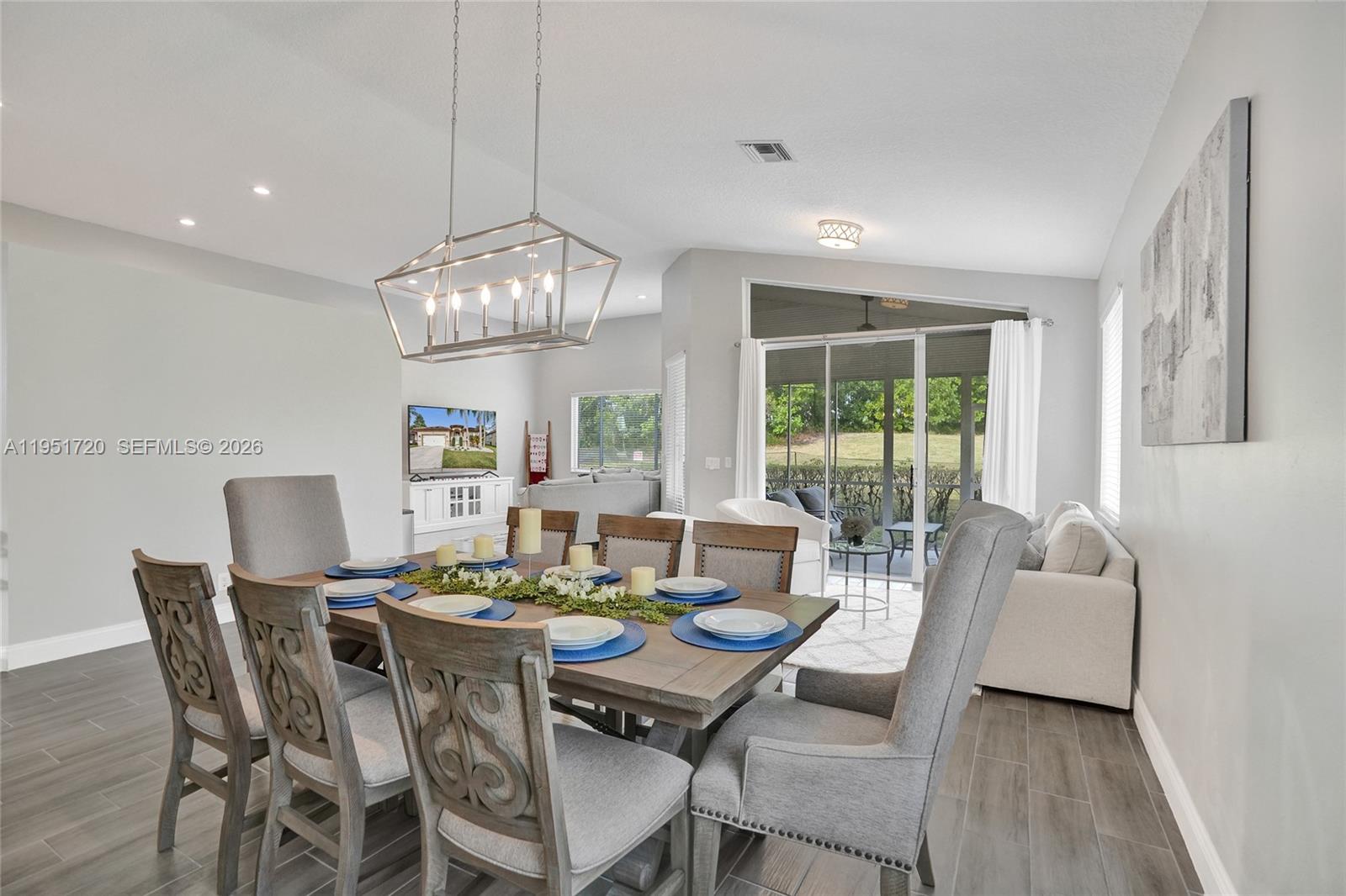 8795 Northwest 76th Place Tamarac, FL 33321 - Photo 7 of 69 a view of a dining room with furniture wooden floor and chandelier