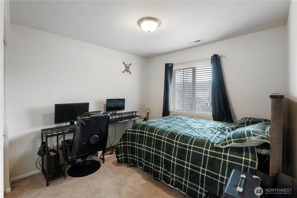 a bedroom with a bed and a flat tv screen on the table