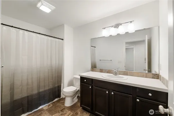 a bathroom with a double vanity sink toilet and a mirror