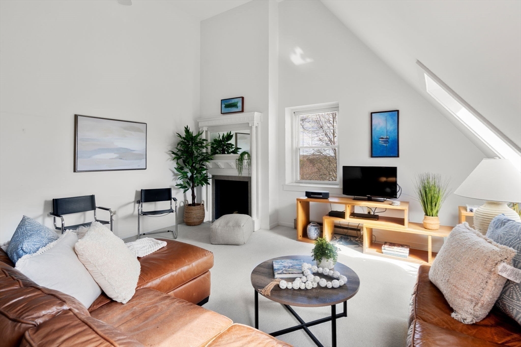 456 Belmont Street, Unit 21 Watertown, MA 02472 - Photo 2 of 19 a living room with furniture a flat screen tv and a fireplace