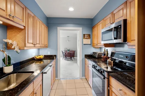 a kitchen with stainless steel appliances granite countertop a stove a sink and a microwave